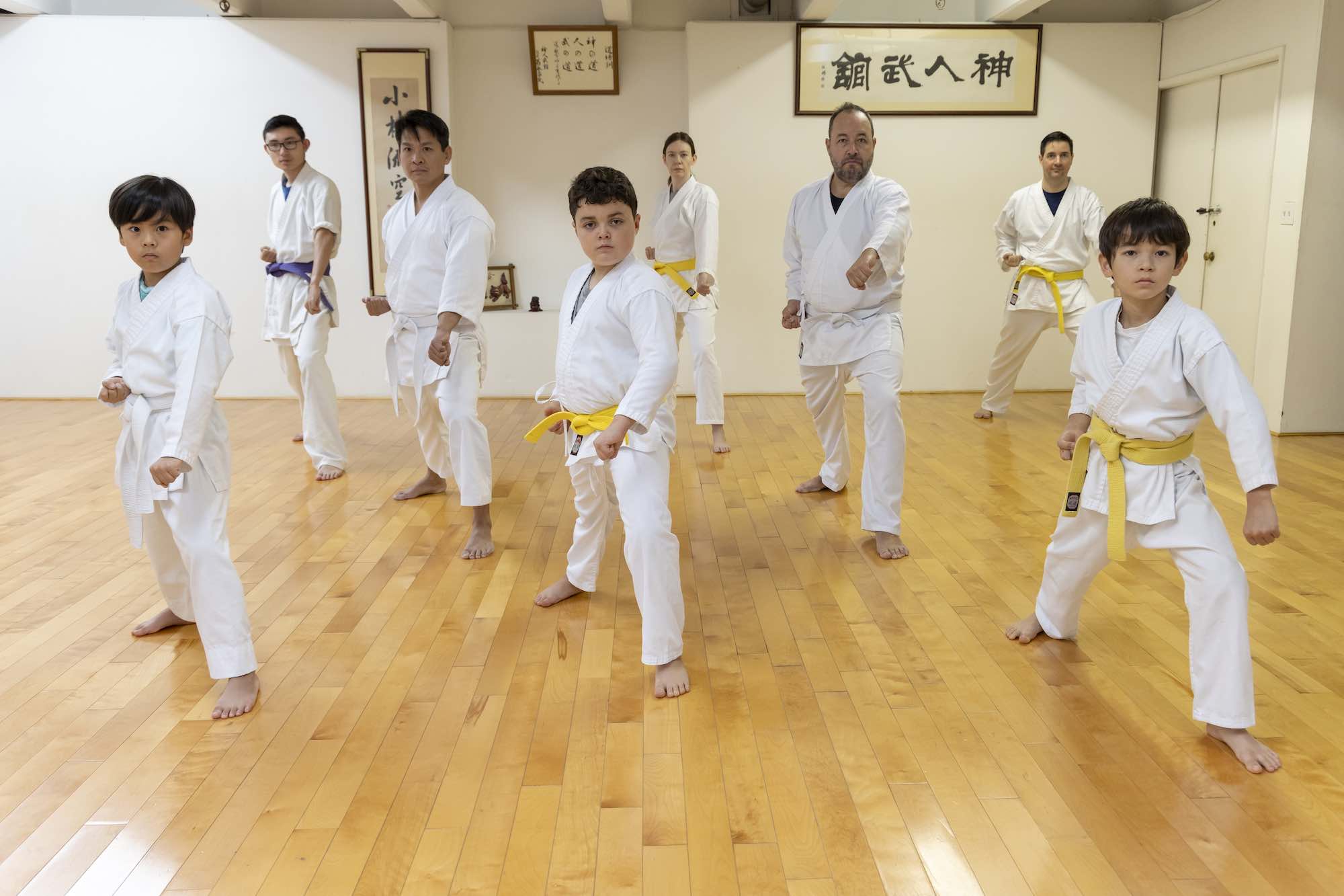 Kids and parents training blocks in the dojo